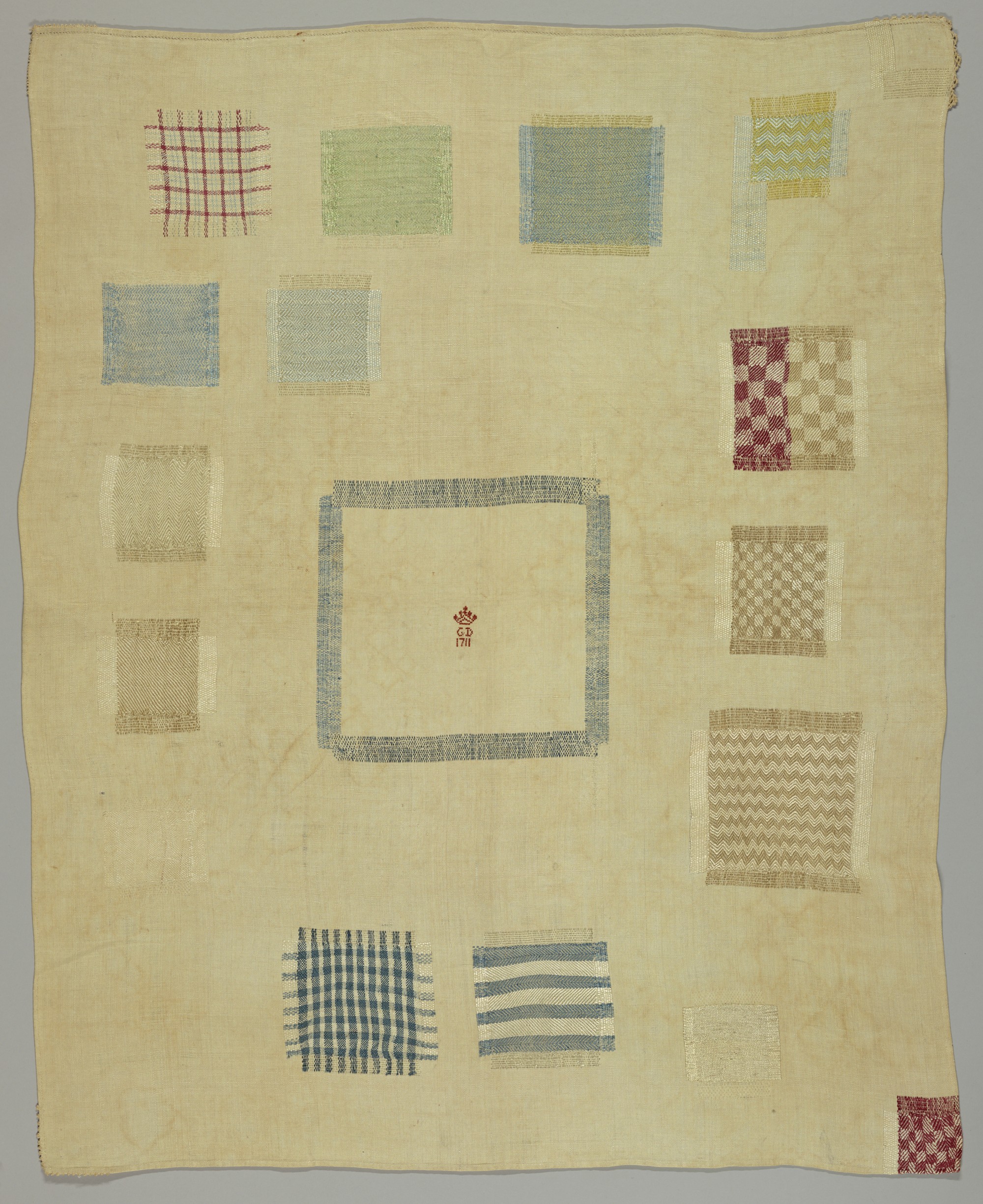 A Dutch linen darning sampler dated 1711, worked with coloured thread in a grid of patterned darning crosses.