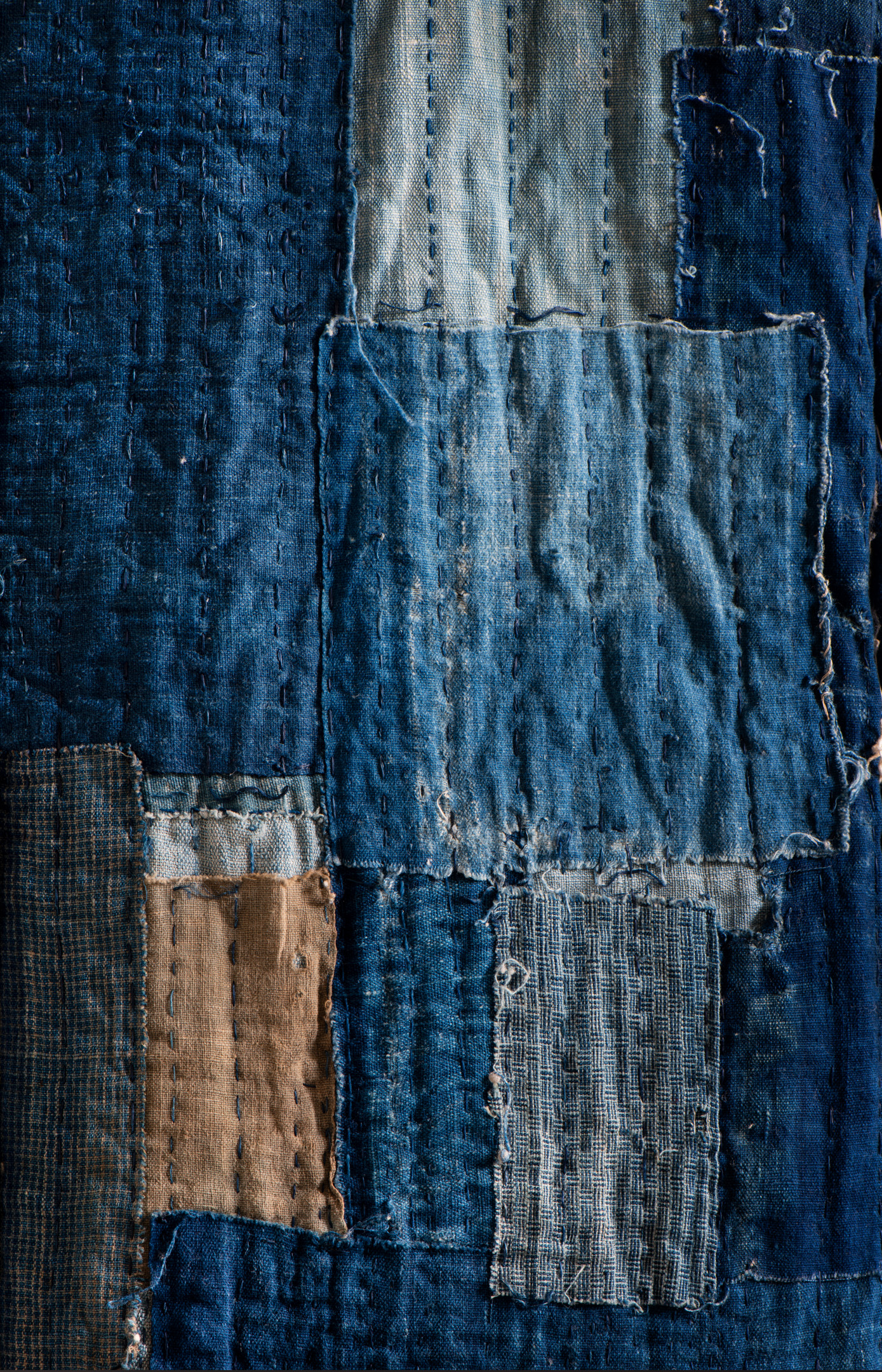 Indigo-dyed Japanese boro quilt with visible sashiko stitching.